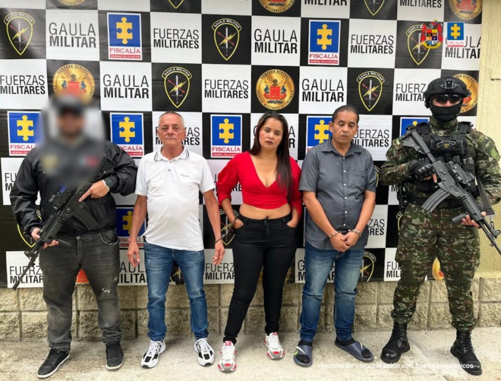En la imagen está una mujer y dos hombres esposados en medio de un servidor del CTI y uno del Ejército Nacional.