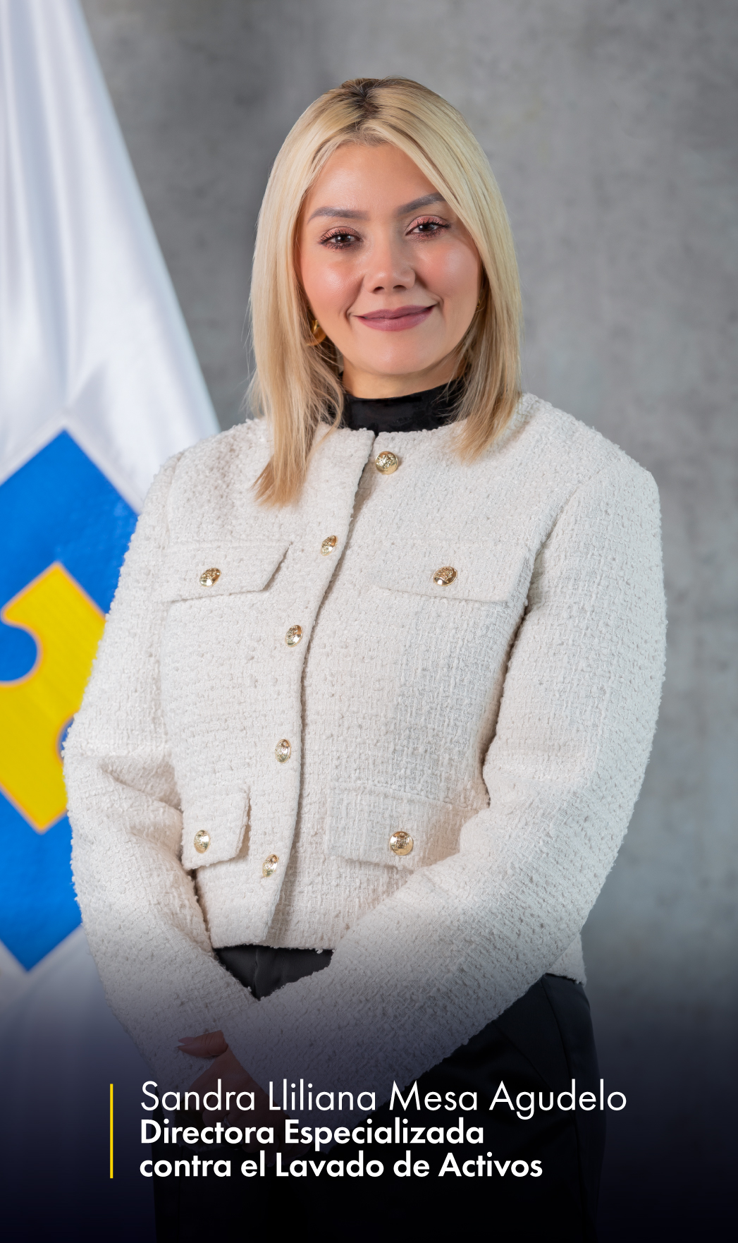 foto de la directora especializada de lavado de activos, se la puede ver con una chaqueta blanca con brazo adelante y a tras de ella la bandera de la fiscalia