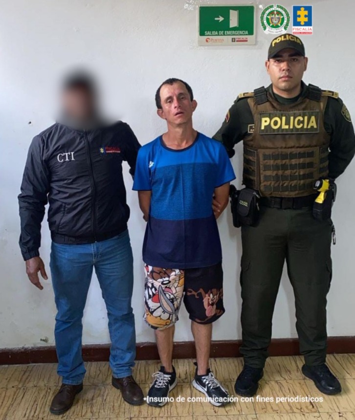 En la fotografía aparece de pie y con los brazos atrás Duván Alejandro García Vallejo. Viste con camiseta de mangas cortas con colores azules degradados, pantaloneta negra con estampado colorido en la manga derecha; asimismo, usa zapatillas negras con zuela y cordones blancos. En su extremo derecho hay un servidor del CTI de  la Fiscalía y en el izquierdo un uniformado de la Policía Nacional.