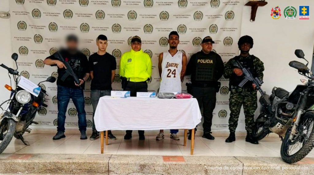 En la fotografía aparecen los dos procesados con servidores del CTI, la Policía Nacional y el Gaula militar con 2 motocicletas incautadas.
