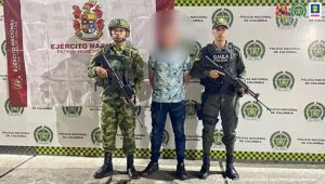 En la fotografía aparece de pie y con los brazos atrás, Duván Camilo Cardona Giraldo, alias Camilo Cagado. Viste camisa de manga corta con estampado, jean azul desgastado y zapatos negros. Al lado derecho de él hay un uniformado del Ejército Nacional y al lado izquierdo un uniformado del Gaula de la Policía Nacional. Detrás de ellos hay dos pendones institucionales del Ejército y la Policía.