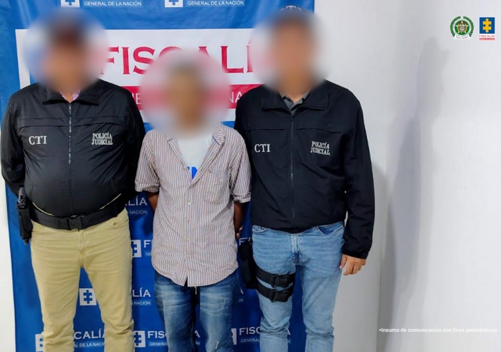 En la imagen aparece una persona de jean y camisa de cuadros entre dos uniformados del CTI de Sucre.