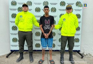 en la foto se aprecia al hoy asegurado siendo custodiado por dos policías.