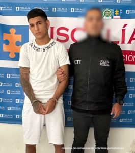 Se visualiza al capturado junto a un investigador del CTI. Detrás de ellos el banner que identifica a la Fiscalía General de la Nación.