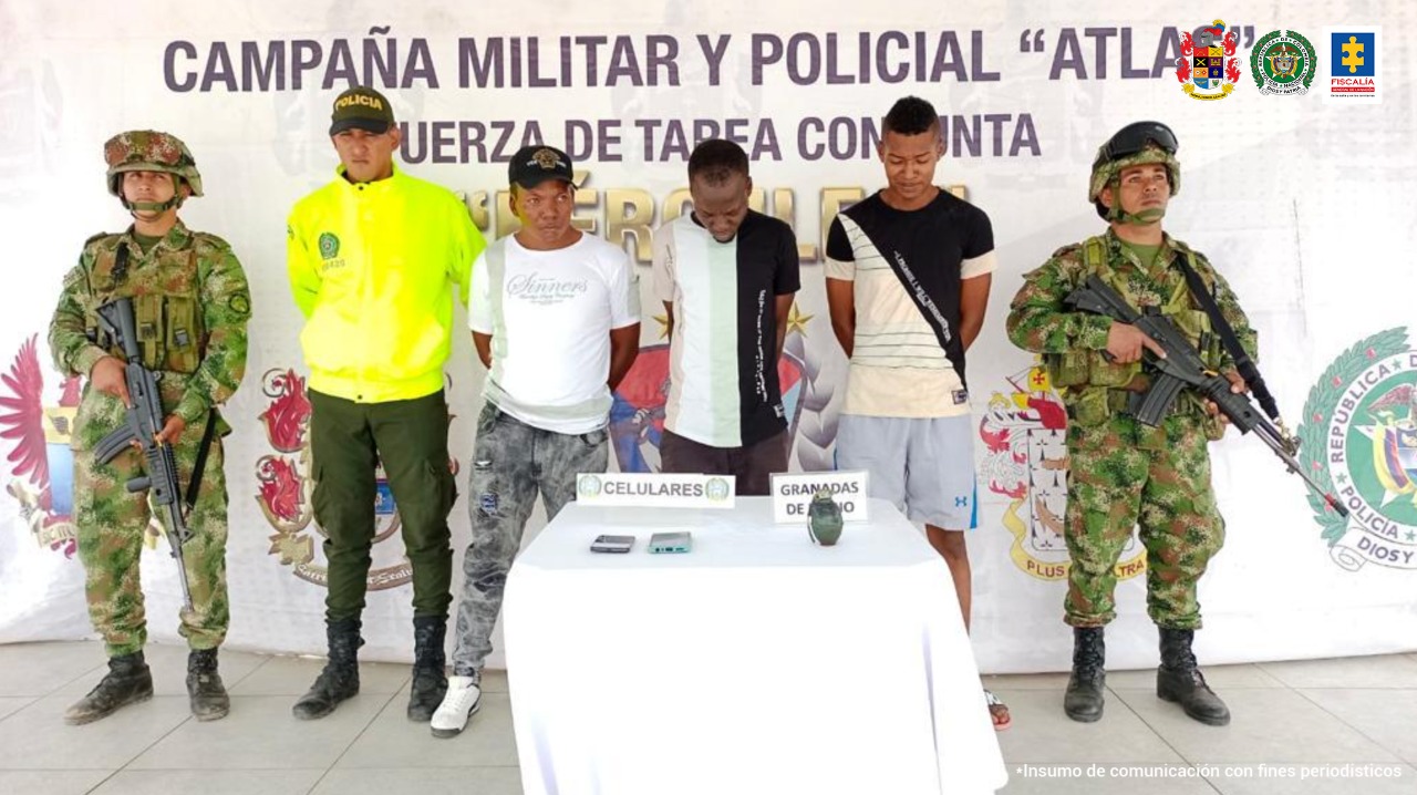 En la fotografía aparecen tres hombres, junto a un agente de la Policía Nacional y dos solados del Ejército. En la parte posterior de la imagen se ve un banner de la Fuerza de Tarea Hércules
