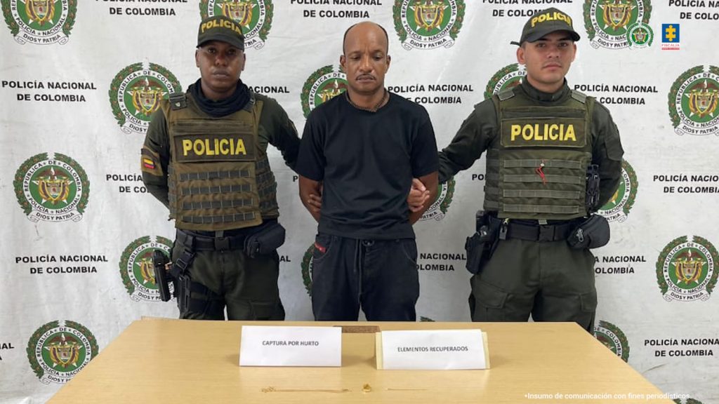 En la fotografía aparecen los dos capturados juntos a cuatro agentes de la Policía Nacional. En la parte superior se observa un banner de la Policía.