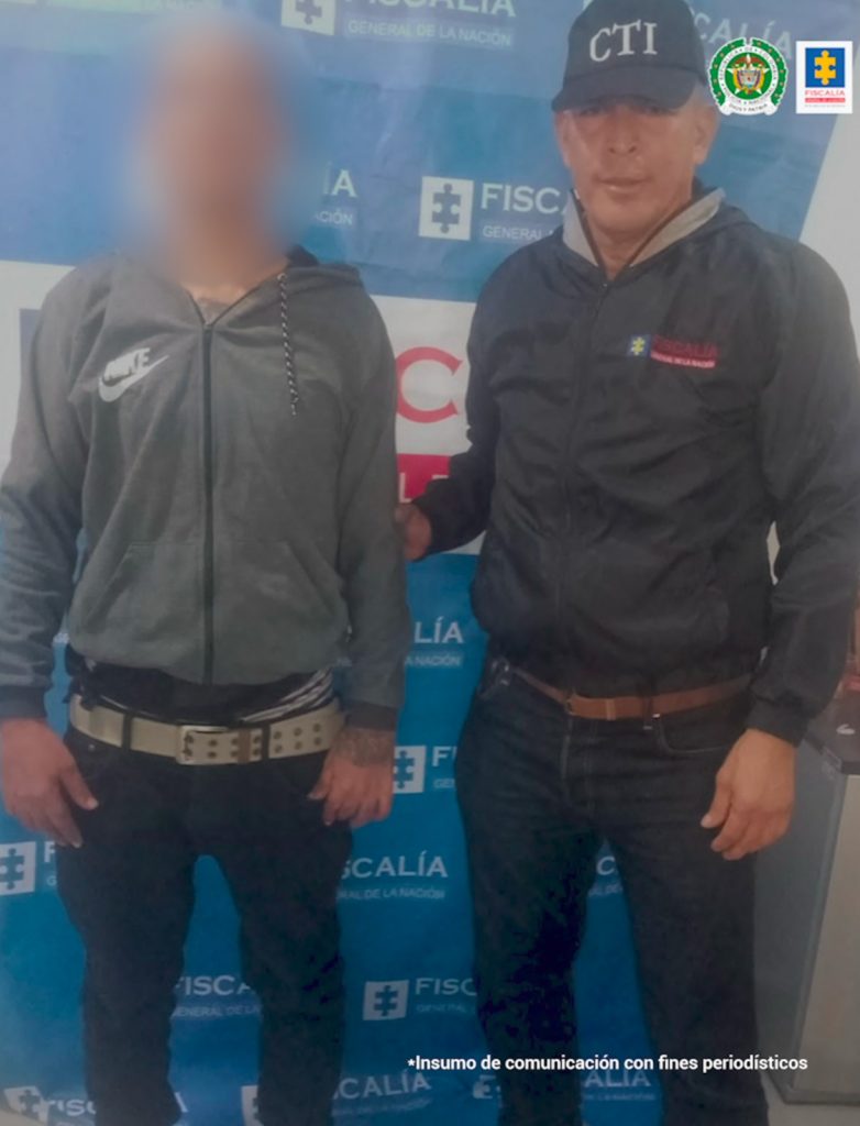 Un investigador adscrito al CTI custodia a este hombre que fue capturado en Santa Marta.