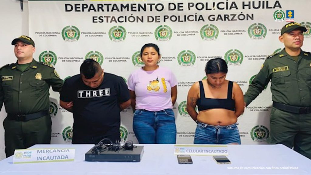 En la foto se observan a los tres capturados custodiados por dos uniformados de la Policía Nacional. También se observa un backing de la Policía Nacional y parte de los elementos incautados durante las capturas.