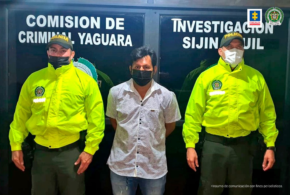 En la fotografía aparece un capturado junto a personal de Policía Nacional. En la parte posterior de la imagen se ven banners de Policía Nacional y la Fiscalía General de la Nación.