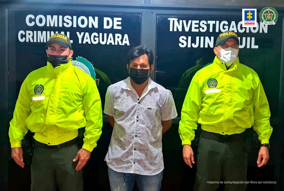 En la fotografía aparece un capturado junto a personal de Policía Nacional. En la parte posterior de la imagen se ven banners de Policía Nacional y la Fiscalía General de la Nación.     