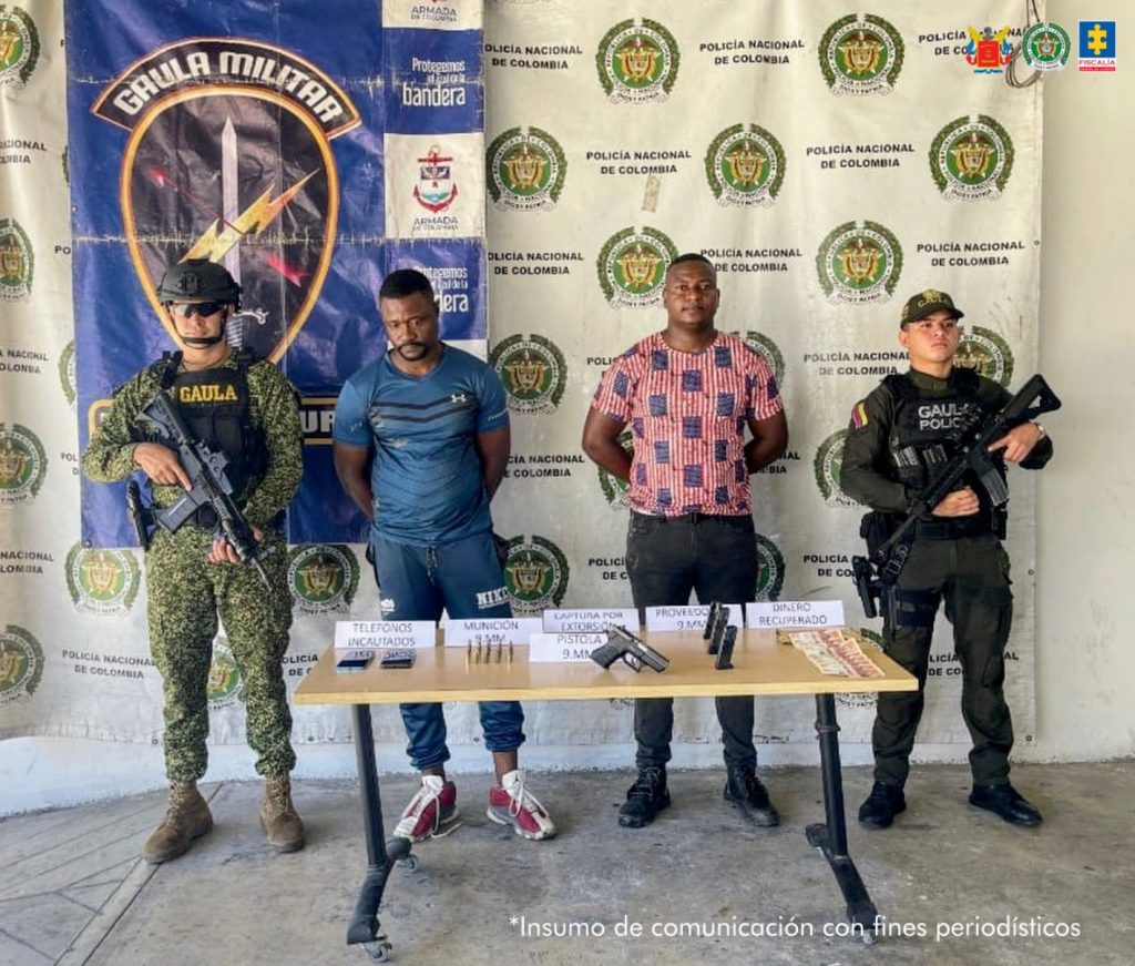 En la fotografía a aparecen los dos capturados junto a un soldado del Gaula de la Armada y un uniformado del Gaula de la Policía Nacional. En la parte posterior está una mesa con teléfonos celulares, un arma, tres proveedores y dinero en efectivo. 