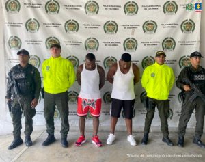 En la imagen aparecen dos de los capturados acompañados por funcionarios de la Policía Nacional