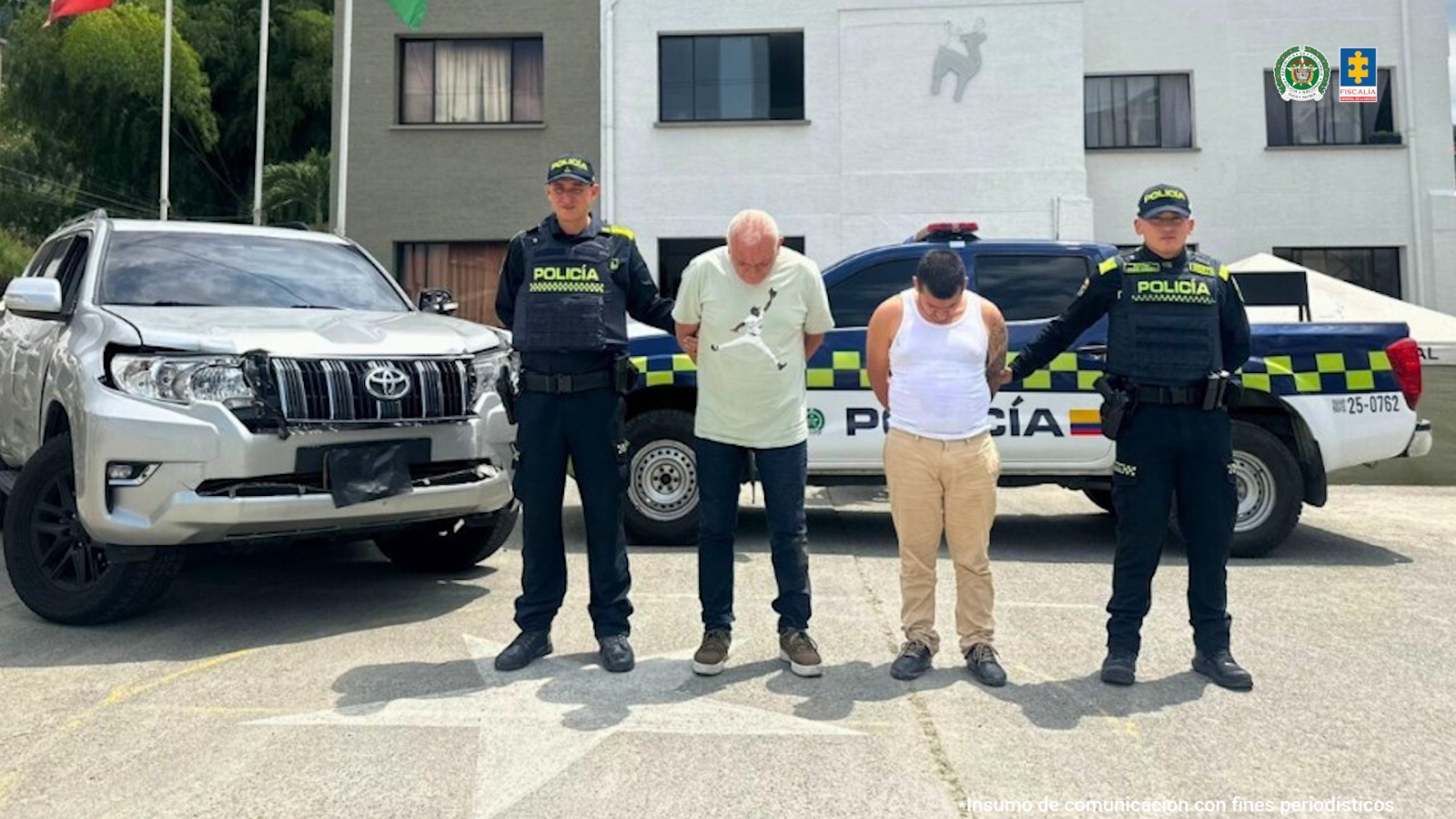 Los hombres capturados aparecen en el centro d ela imagen. Atrás pueden verse dos vehículos, uno de ellos de la Policía. Los capturados están rodeados de personal de la Policía.