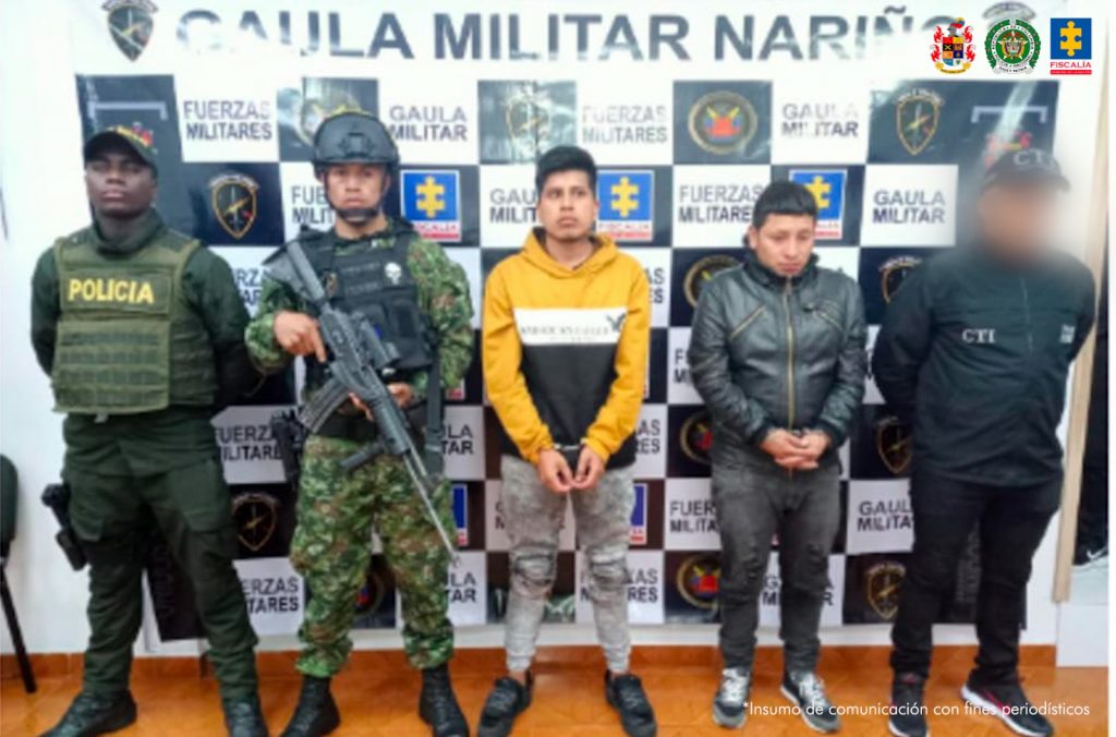 En la fotografía aparecen los dos capturados junto a un servidor del CTI, un soldado del Gaula Militar y un agente de la Policía. En la parte superior se observa un banner del Gaula Militar