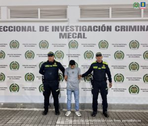 En la fotografía se aprecia de pie y con los brazos atrás a Eyner Antonio Guevara Moreno. Viste camiseta de color gris, de manga corta y con un estampado pequeño, de color negro a la altura del pecho; usa jean azul desgastado y zapatillas blancas con negro. A sus extremos hay uniformados de la Policía Nacional. Detrás de ellos hay un pendón institucional de la Policía.
