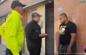 En la fotografía aparece el capturado junto un servidor del CTI y un agente de la Policía Nacional. En la parte superior está un banner del grupo EDA de la Fiscalía General y un banner de la Policía NacionalPie de foto: Silvio Andrés Ramírez Domínguez fue imputado con cargos coMo presunto autor de feminicidio agravado