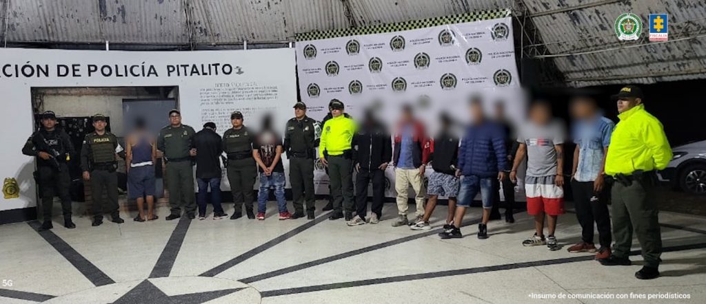 Los imputados se encuentran en custodia por dos uniformados de la Policía Nacional. Detrás de él se observa un backing de la Policía.