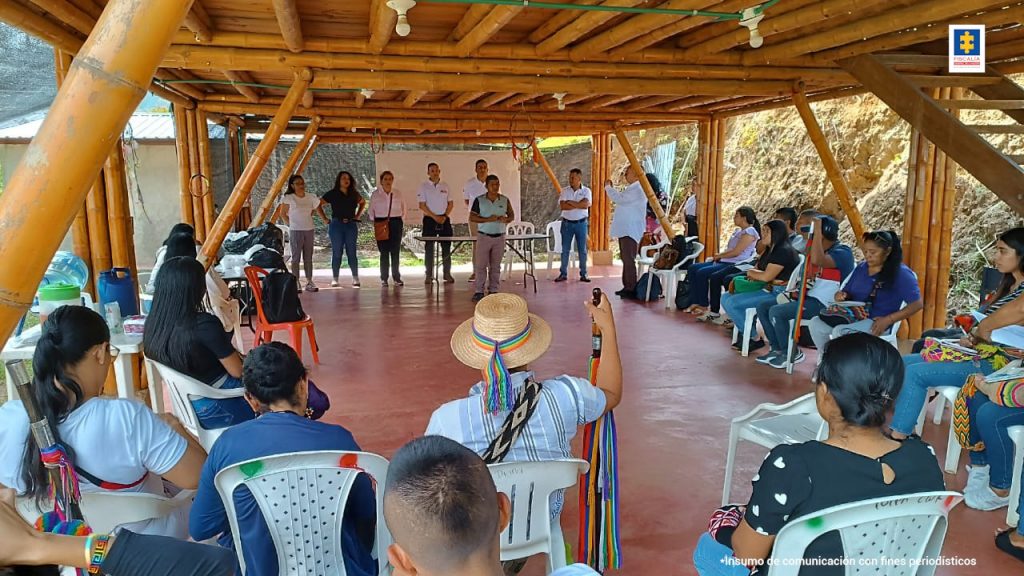 En la fotografía se aprecia a representantes de la Fiscalía y de las comunidades ancestrales reunidos en un espacio semiabierto. Al fondo, personal de la Dirección Seccional de Fiscalías Cauca están de pie en señal de exposición. Representantes de las comunidades indígenas se encuentran sentados en simicírculo.
