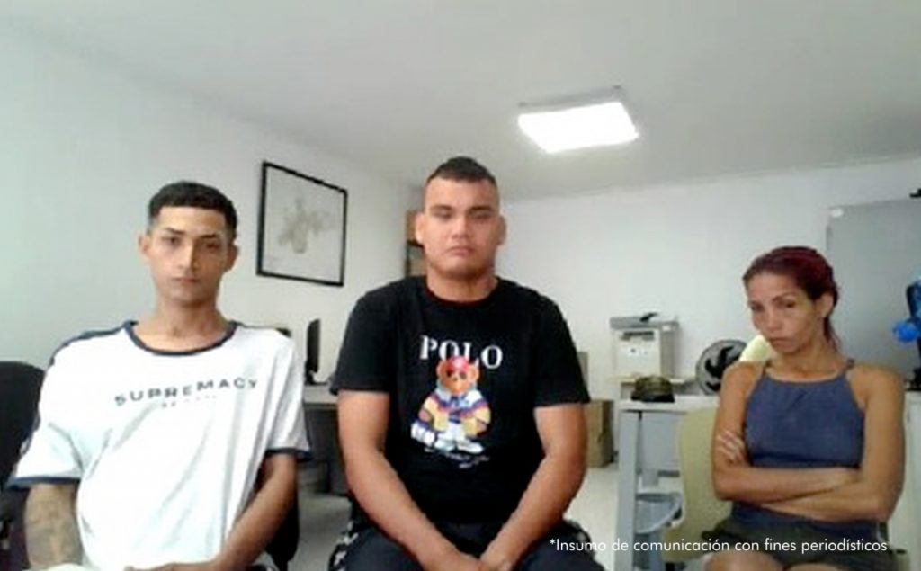 En la imagen se ve a dos hombres y una mujer que están atentos a la audiencia de imputación de cargos.