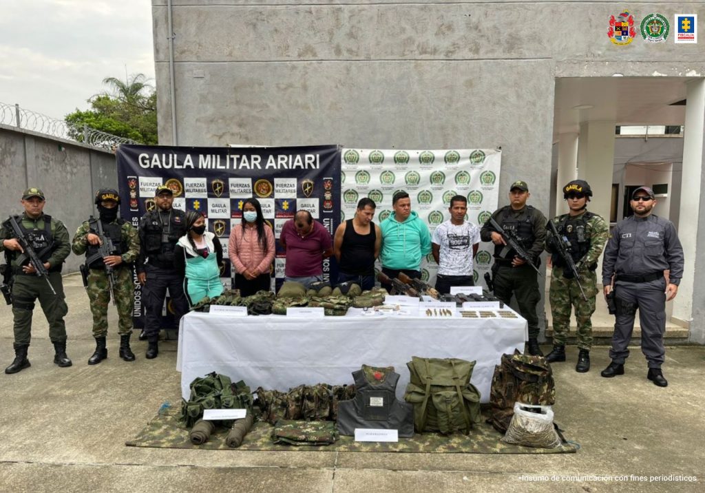 Los capturados aparecen esposados y custodiados por servidores de la Fiscalía, Gaula policía y ejército, y en una mesa frente a ellos están los elementos incautados como armas y material de intendencia y comunicaciones.