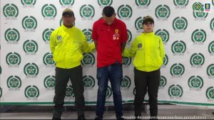 Los tres capturados aparecen custodiados por uniformados de la Policía, y esposados.