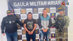 Los dos capturados están esposados, con sus manos adelante y están en medio de dos servidores, uno del CTI de la Fiscalía y el otro es un miembro del ejército nacional.