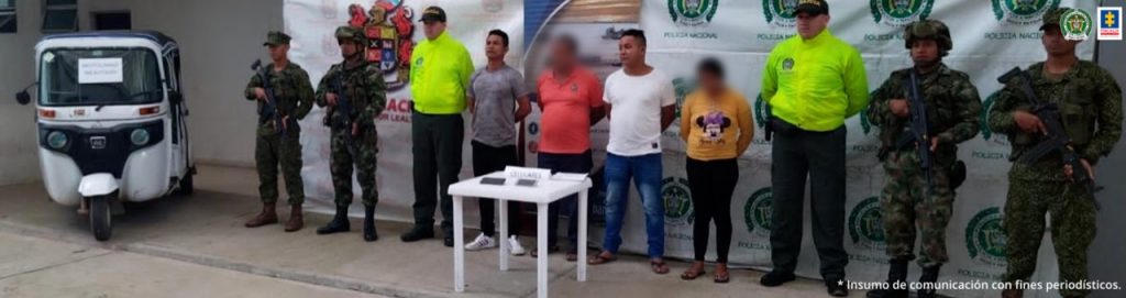 Las cuatro personas capturadas, entre ellas una mujer, están esposados a su espalda y con algunos elementos incautados sobre una mesa, están custodiados por uniformados de la Policía, el Ejército y la Armada Nacional.
