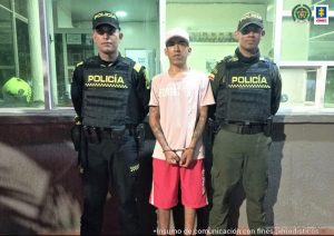 Los tres capturados aparecen custodiados por uniformados de la Policía, y esposados.