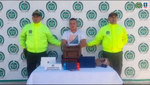 El capturado está sujetado por dos uniformados de la policía nacional, y en una mesa está algunos de los elementos que, al parecer, habría hurtado días atrás.