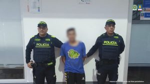 Cada procesado aparece en una fotografía individual con sus manos esposadas y siempre custodiados por uniformados de la Policía. De fondo, está ubicado un pendón institucional.