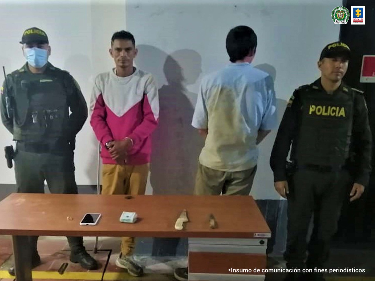 Los capturados se encuentran esposados, uno de ellos quien usa muletas porque le falta su pierna derecha está de frente, mientras que el otro procesado está de espaldas.