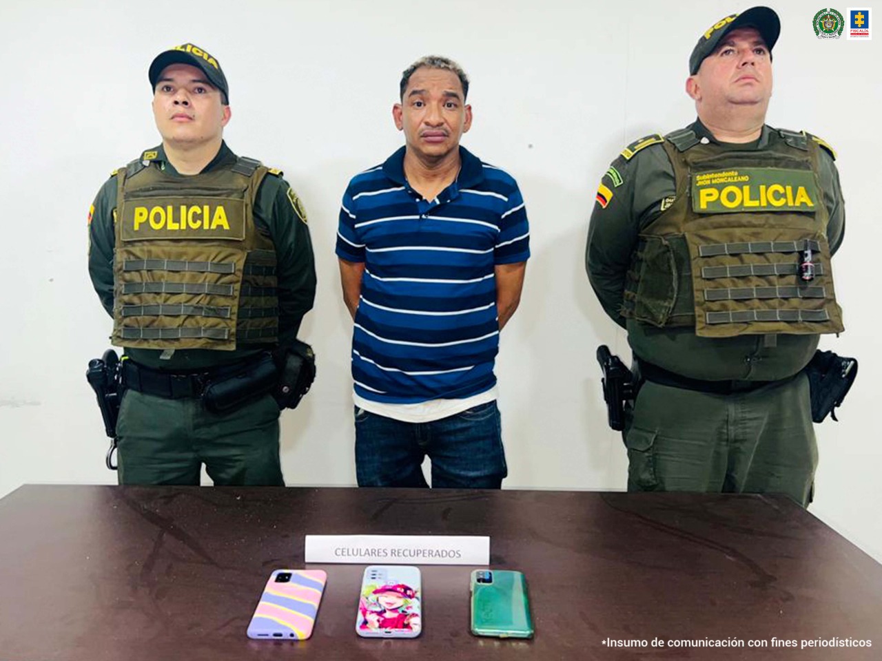 El capturado está en medio de dos uniformados de la Policía Nacional y en una mesa están los tres celulares que presuntamente el capturado había hurtado momentos antes de su captura.