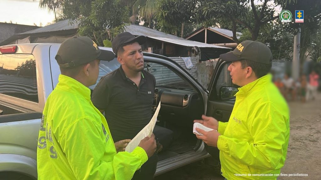 El condenado aparece junto a dos uniformados de la policía, en momentos en que era capturado.