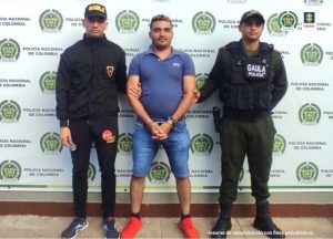 Aparece el capturado escoltado por dos oficiales de la Policía.