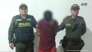 Cada procesado aparece en una fotografía individual con sus manos esposadas y siempre custodiados por uniformados de la Policía. De fondo, está ubicado un pendón institucional.