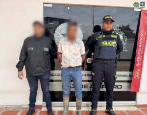 El procesado aparece en medio de dos uniformados de la policía que lo custodian.