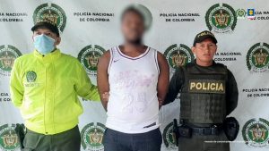 En la fotografía aparece el capturado junto a dos integrantes de la Policía Nacional. En la partesuperior está un banner de la Policía Nacional