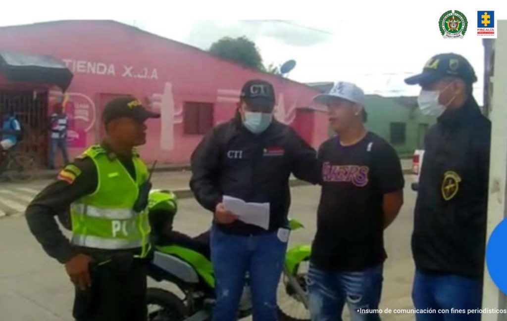 En la imagen se aprecia una persona detenida, junto con dos funcionarios de la Policía y uno de la Fiscalía.