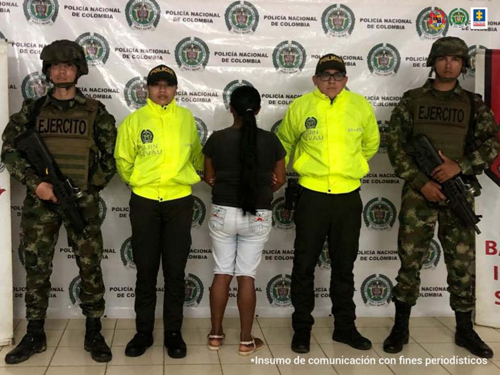 En la foto se observa a la detenida junto a dos agentes de la Policía y dos soldados del Ejército.
