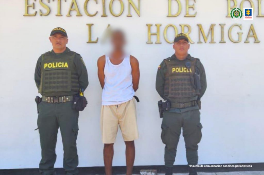 En las fotografía aparece un capturado, junto a personal Policía Nacional. En la parte posterior de la imagen se ve un banner de Policía Nacional.