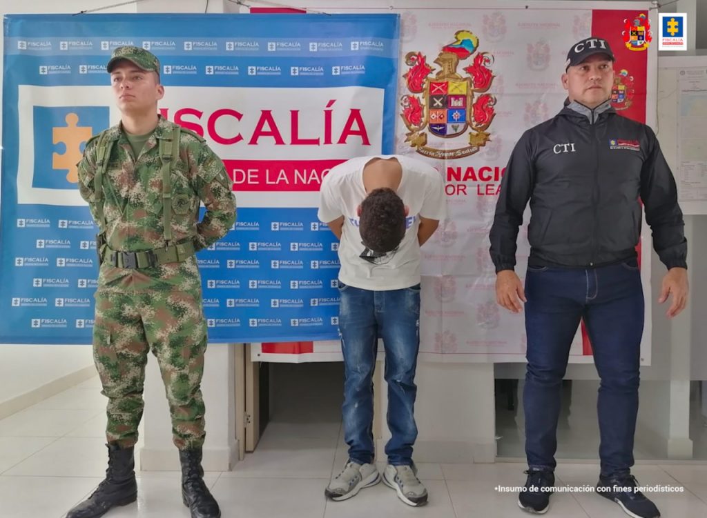 En las fotografía aparece un capturado, junto a personal de CTI y Ejército Nacional. En la parte posterior de la imagen se ven banners de Ejército Nacional y la Fiscalía General de la Nación.