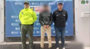 Fiscal Mancera, Fiscal Martha Mancera, Martha Mancera, Fiscalía General de la Nación Se visualiza al capturado con el rostro difuminado junto a un uniformado de la Policía Nacional y un investigador del CTI. Detrás el banner que identifica a la Policía Nacional.