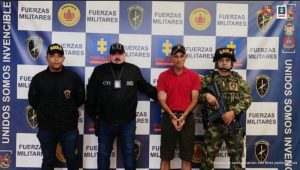 Fiscal Mancera, Fiscal Martha Mancera, Martha Mancera, Fiscalía General de la Nación capturado de frente custodiado por un investigador del CTI de la Fiscalía y un policía. Detrás banner de grupo Gaula Militar.