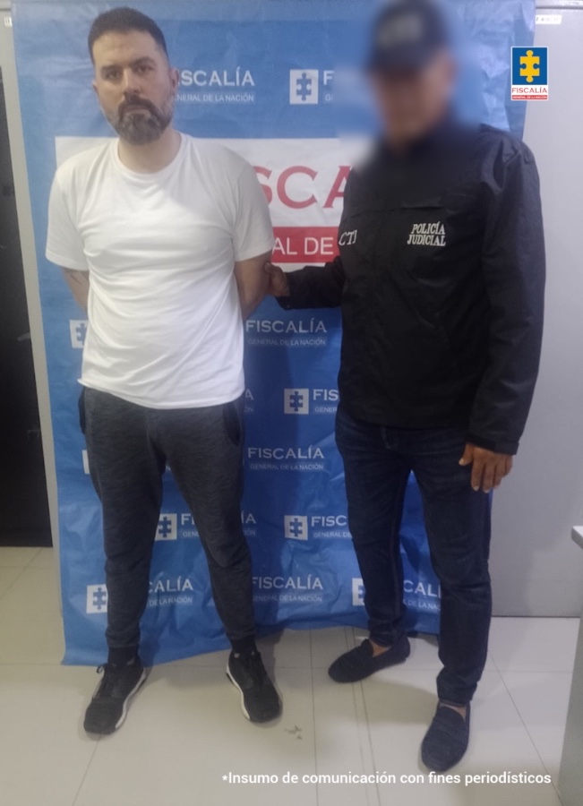 Un funcionario del CTI de la Fiscalía del Magdalena custodia al procesado tras su captura en Santa Marta, en el sector de Los Cocos.