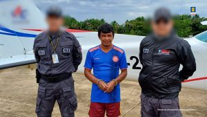 El capturado está esposado y custodiado por dos servidores del CTI.