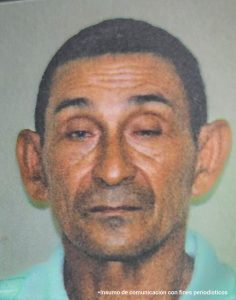En la imagen se ve el rostro de un hombre trigueño, cabello negro, orejas grandes, con labios delgados y ojos pequeños.