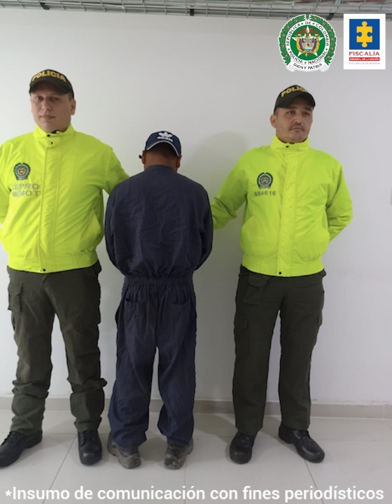 En la imagen se observa a un hombre vestido de enterizo de jean azul con una gorra del mismo color, custodiado por dos agentes de la Policía Nacional.