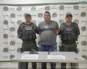 En la imagen está el rostro de un hombre moreno de contextura gruesa de cabellos cortos crespos negros, vestido con una camiseta azul. El procesado se encuentra al interior de una oficina asistiendo virtualmente a la audiencia en la que se le procesó.