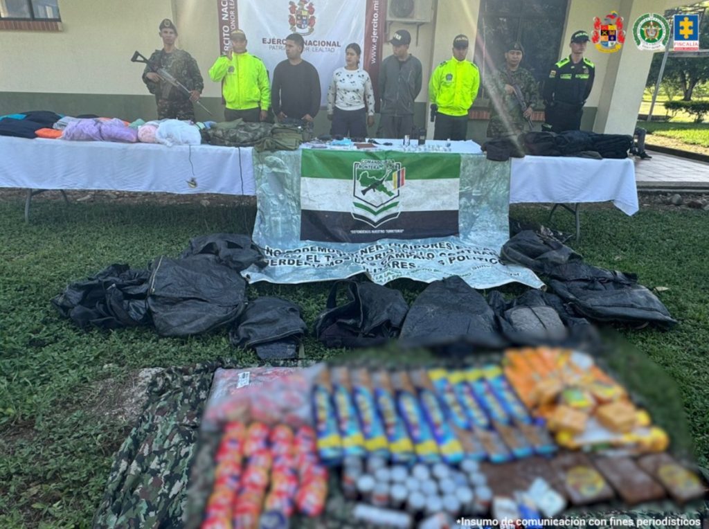 Los capturados se encuentran de frente y custodiados por uniformados de la Policía y Ejército Nacional. Detrás de la foto hay un backing del Ejército Nacional y en la foto se observa parte del material incautado.