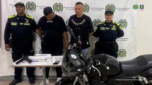 Cali y Jamundí (Valle del Cauca), 29 de noviembre de 2024. La Fiscalía General de la Nación judicializó y corrió escrito de acusación contra tres hombres por el delito de hurto calificado y agravado. Estas personas estarían involucradas en asaltos violentos, ocurridos el pasado 25 de agosto. Uno de estos casos ocurrió en Jamundí (Valle del Cauca), en donde Brayan Andrés Sierra Vásquez y Milciades Cruz Peña habrían intimidado con arma de fuego a un hombre cuando salía de un taller automotriz ubicado en el barrio Libertadores, para despojarlo de sus pertenencias. En Cali, a su vez, fue judicializado Darío Johan Montoya Valencia, quien habría intimidado con un arma de fuego a tres personas para hurtarles sus celulares. Las víctimas se movilizaban por una vía pública del barrio San Marcos. Los tres hombres fueron capturados en flagrancia cuando intentaban huir del lugar y tenían en su poder los elementos que habrían hurtado. Ninguno aceptó los cargos imputados y un juez de control de garantías les impuso medida de aseguramiento en centros carcelario. MAP/CFG/DSC/AMCJ/ (Fotos) Pie de foto 1: Brayan Andrés Sierra Vásquez y Milciades Cruz Peña habrían hurtado de manera violenta las pertenencias de un ciudadano en el municipio de Jamundí (Valle del Cauca). Texto alternativo foto 1: En la fotografía aparecen de pie Brayan Andrés Sierra Vásquez y Milciades Cruz Peña. Uno de elos viste camiseta de manga corta, de color negro; pantalón negro y zapatillas blancas. El otro viste camiseta de manga corta, de color negro con la palabra ‘Streetma’ estampada, a la altura del pecho, en color blanco; jean azul. A los extremos de ellos hay uniformados de la Policía Nacional. Delante de ellos hay una mesa y sobre ella se aprecia un arma de fuego y un celular. Asimismo, tres letreros que dicen: ‘Elementos’, ‘Armas traumáticas’, ‘Recuperación de celular’. Asimismo, hay una motocicleta. Detrás de ellos hay un pendón institucional de la Policía Nacional.